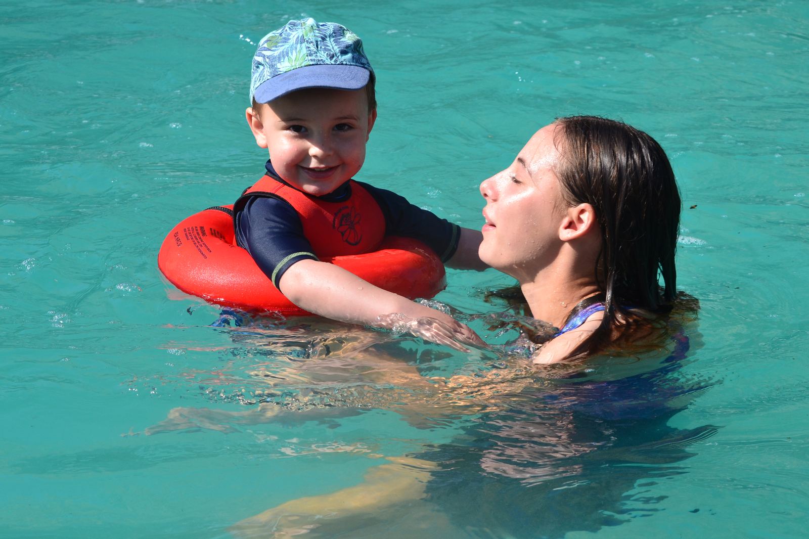 Mum holding her smiling baby in the pool